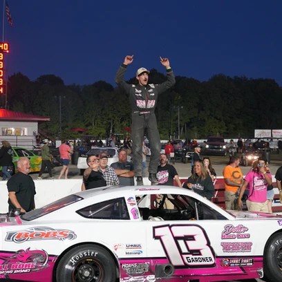 Scotty Gardner On the roof of his car in victory lane celebrating